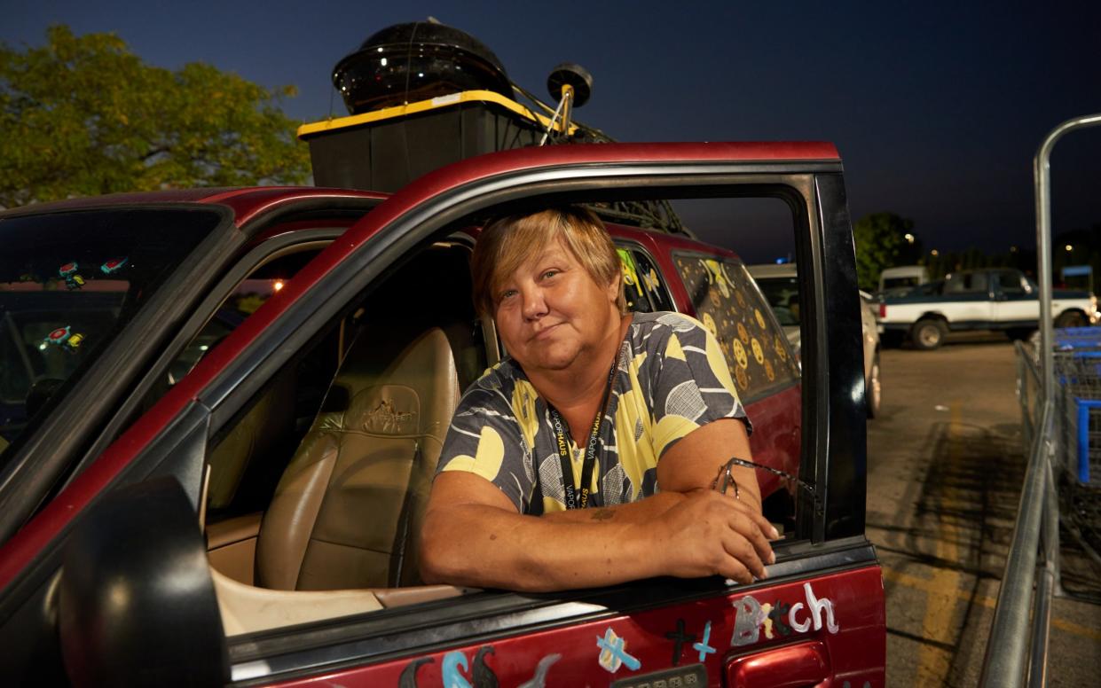 Maggie Crooks hangs out of the window of an SUV in which she has been living