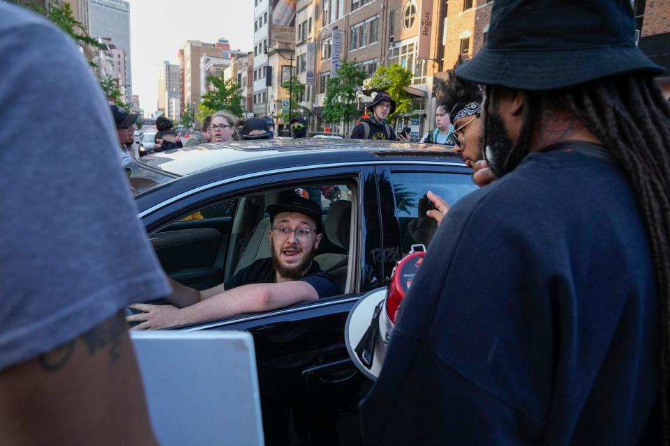 May 20, 2023; Columbus, Ohio, US;  A motorist engages with protestors as they march on South High Street during a protest for Sinzae Reed, a 13-year-old who was shot and killed in Columbus’ Hilltop neighborhood on Oct. 12, 2022 by Krieg Butler. A Franklin County grand jury recently declined to file murder charges for Butler. 