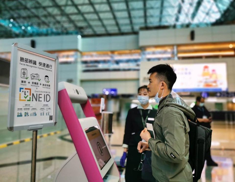 透過航空公司地勤人員協助，旅客試用「One ID臉部辨識系統」於自助報到機拍攝臉部特徵建立資料。（圖：交通部）