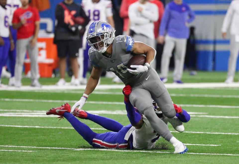 Lions wide receiver Amon-Ra St. Brown makes a catch against Bills safety Damar Hamlin during the second half of the Lions' 28-25 loss on Thursday, Nov. 24, 2022, at Ford Field.