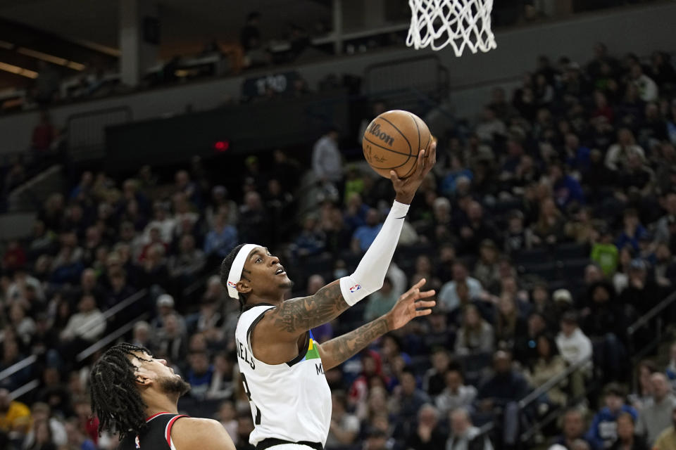 Minnesota Timberwolves forward Jaden McDaniels shoots while defended by Portland Trail Blazers forward Trendon Watford during the first half of an NBA basketball game, Sunday, April 2, 2023, in Minneapolis. (AP Photo/Abbie Parr)