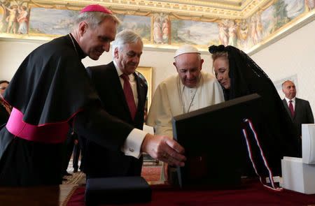 Chile's President Sebastian Pinera and his wife Cecilia Morel exchange gifts with Pope Francis as they meet during a private audience at the Vatican October 13, 2018. REUTERS/Alessandro Bianchi/Pool