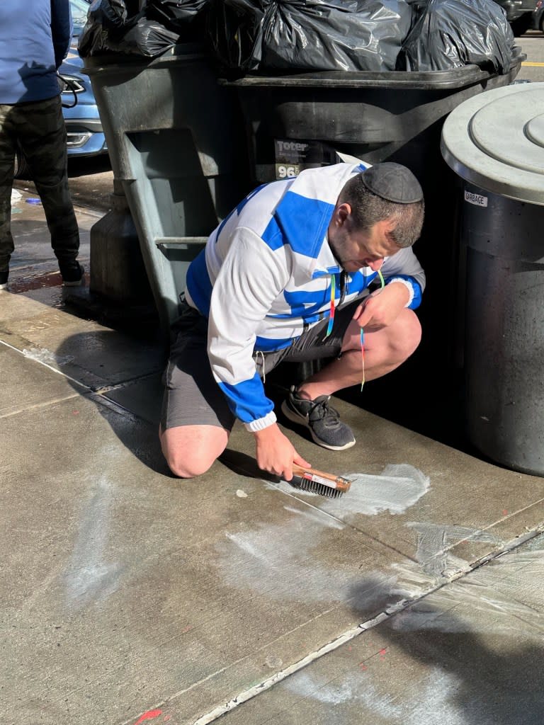Locals stepped in to help scrub the graffiti from the sidewalk. Melanie Notkin for the NYPost