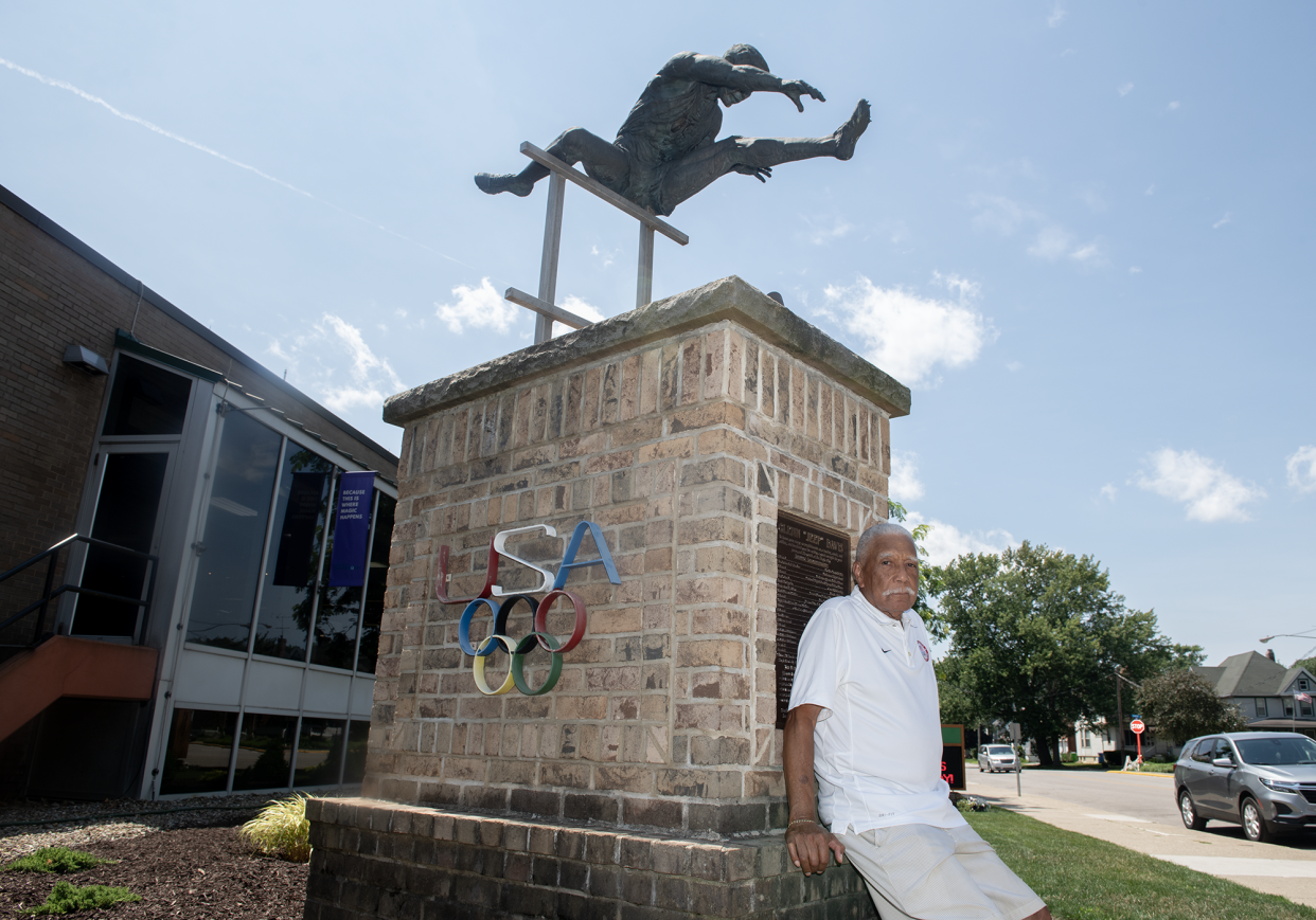 Lester Carney, 90, of Akron, who won a silver medal at the 1960 Rome Olympics in the 200 meters, poses with the Glenn "Jeep" Davis statue next to Barberton Public Library. Carney and Davis were friends who competed in the 1960 Summer Games.