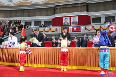 Children present flowers to North Korean leader Kim Jong Un, his wife Ri Sol Ju, China's President Xi Jinping and his wife Peng Liyuan during Xi's visit in Pyongyang, North Korea in this undated KCNA photo