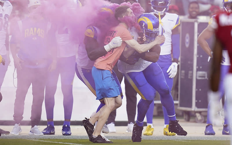 A protester is hit by Los Angeles Rams defensive end Takkarist McKinley and linebacker Bobby Wagner