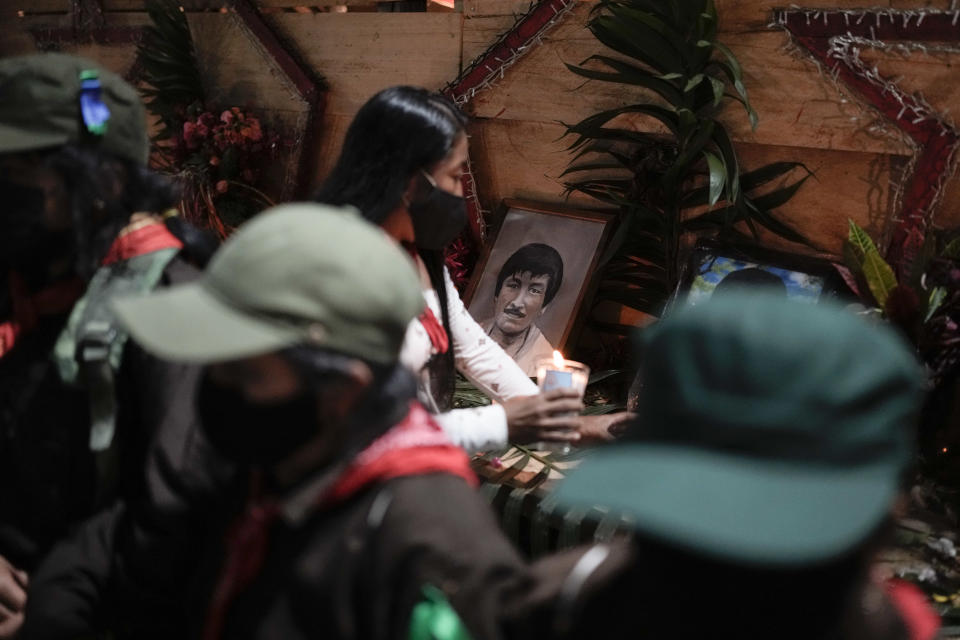 A members of the Zapatista National Liberation Army places a candle in front of a photo of comandante Hugo during an event marking the 30th anniversary of the Zapatista uprising in Dolores Hidalgo, Chiapas, Mexico, Sunday, Dec. 31, 2023. (AP Photo/Eduardo Verdugo)