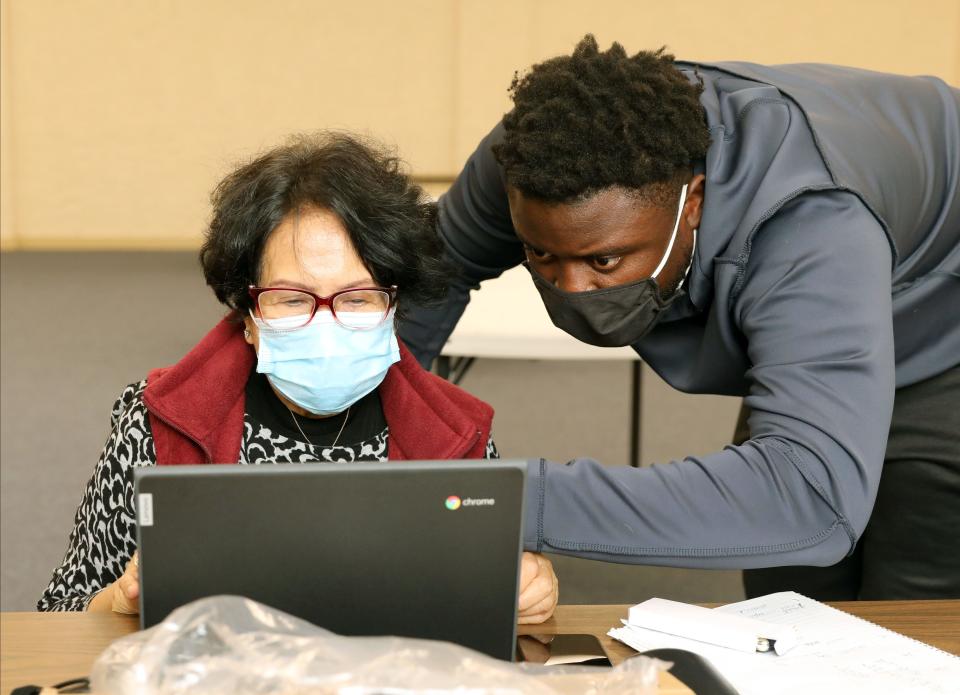 Frantz Lucien Jr., the STEM Alliance Outreach and Engagement Coordinator for the Y-Zone, works with Fe Bulatewicz on learning the basics of computing, during a class at 111 Waverly Street in Yonkers, Dec. 1, 2021.