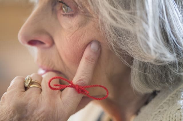 Close Up Of Senior Woman With String Tied Around Finger As Reminder