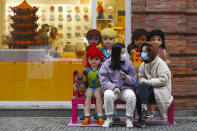 In this photo released by Xinhua News Agency, women wearing protective masks to prevent the new coronavirus outbreak chat with each other outside a Lego store at a re-opened commercial street in Wuhan in central China's Hubei province on Monday, March 30, 2020. Shopkeepers in the city at the center of China's virus outbreak were reopening Monday but customers were scarce after authorities lifted more of the anti-virus controls that kept tens of millions of people at home for two months. (Shen Bohan/Xinhua via AP)