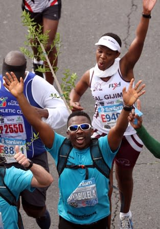 Activist and treegrower Sokomani celebrates as he approaches the final stretch of the Cape Town marathon