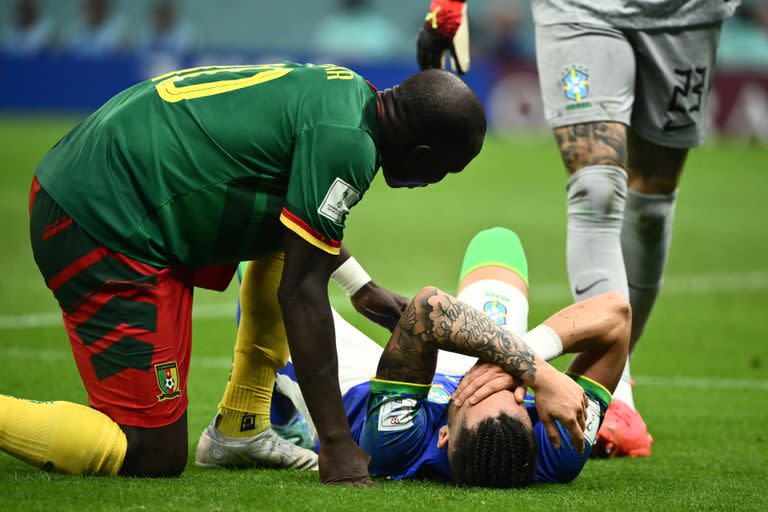 Brazil's defender #16 Alex Telles (C) reacts after picking up an injury during the Qatar 2022 World Cup Group G football match between Cameroon and Brazil at the Lusail Stadium in Lusail, north of Doha on December 2, 2022. (Photo by Jewel SAMAD / AFP)