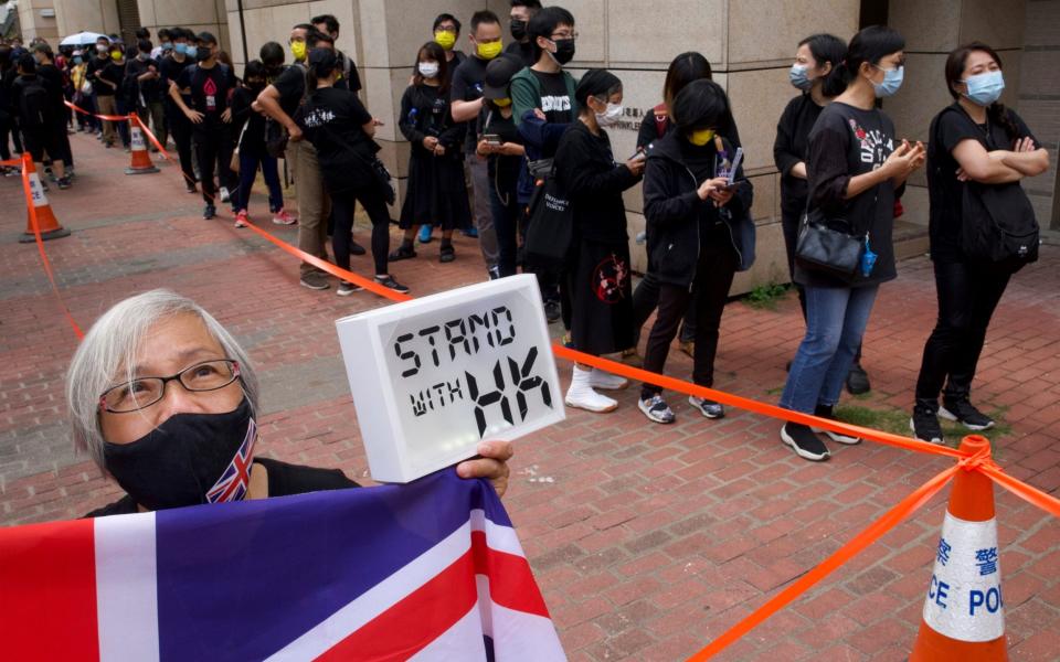 Pro-democracy supporters queue up outside a court to try to get in for a hearing in Hong Kong  - Vincent Yu /AP