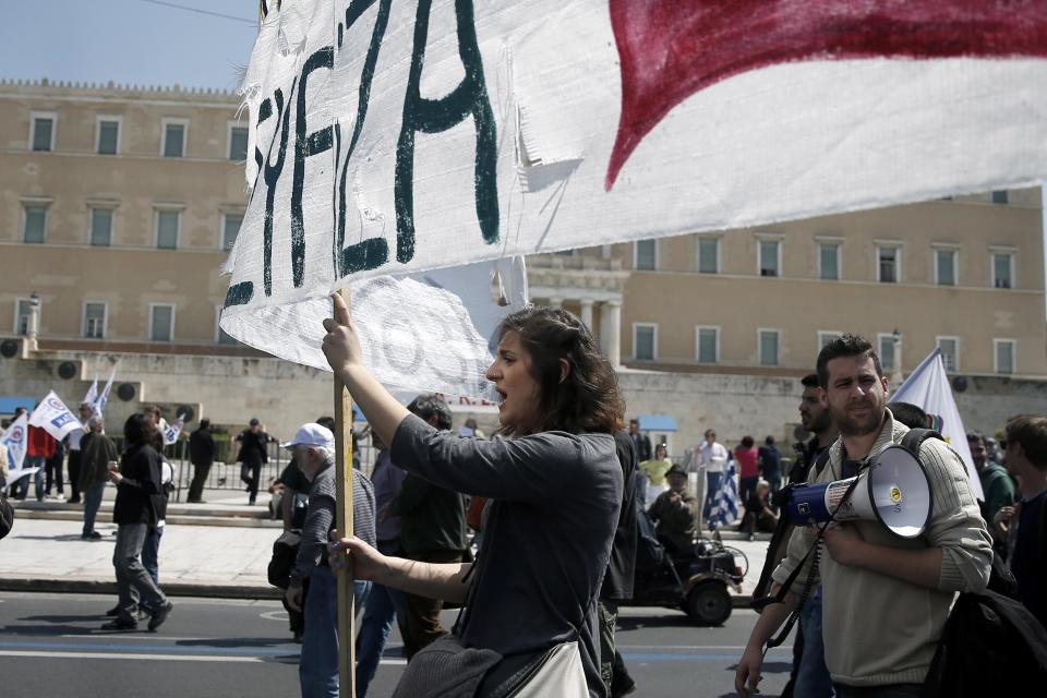 Protesters carry banner in front of the Greek Parliament during a 24-hour nationwide general strike, in Athens, Wednesday, April 9, 2014. Unions say they are seeking an end to the painful savings policies that successive governments imposed to secure international bailout loans after Greece nearly went bankrupt in 2010. The repeated income cuts and tax hikes deepened a six-year recession, while unemployment has reached a record 28 percent. (AP Photo/ Petros Giannakouris)