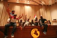 Iraqi protesters flash V-signs inside the parliament building after breaking into Baghdad's heavily fortified Green Zone on April 30, 2016