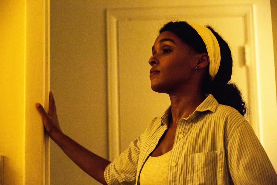 Janelle Monae stands in a doorway