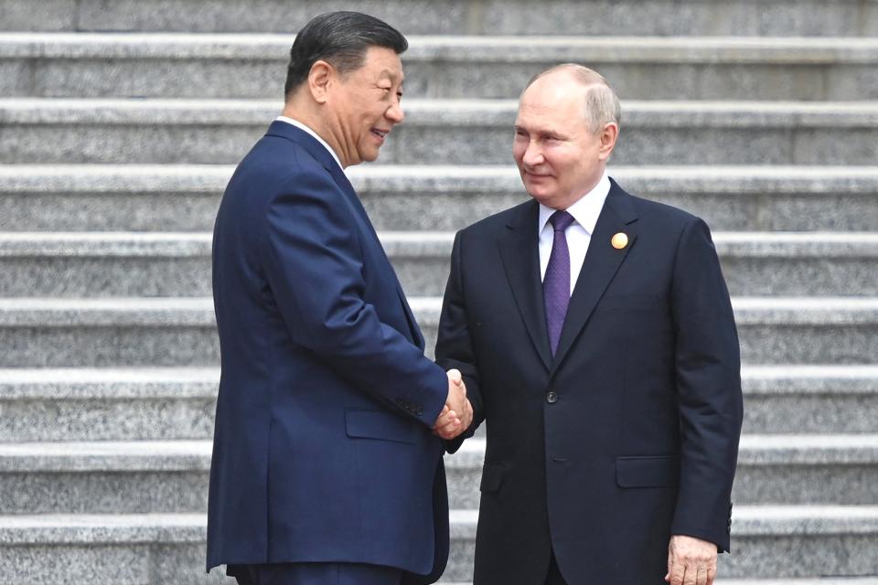 Vladimir Putin (R) and China's President Xi Jinping shake hands during an official welcoming ceremony in front of the Great Hall of the People in Tiananmen Square in Beijing (RUSSIAN PRESIDENTIAL PRESS OFFIC)