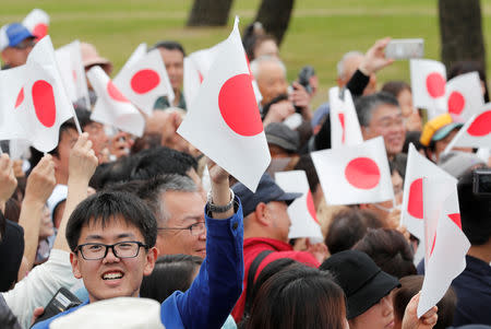 People wave Japanese flags as they wait for Emperor Naruhito outside the Imperial Palace in Tokyo, Japan May 1, 2019. REUTERS/Kim Kyung-Hoon