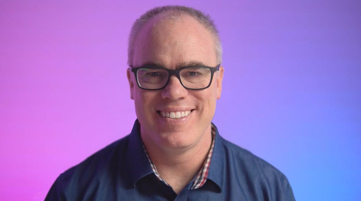 Brian Galvin headshot against a purple and blue gradient backdrop.