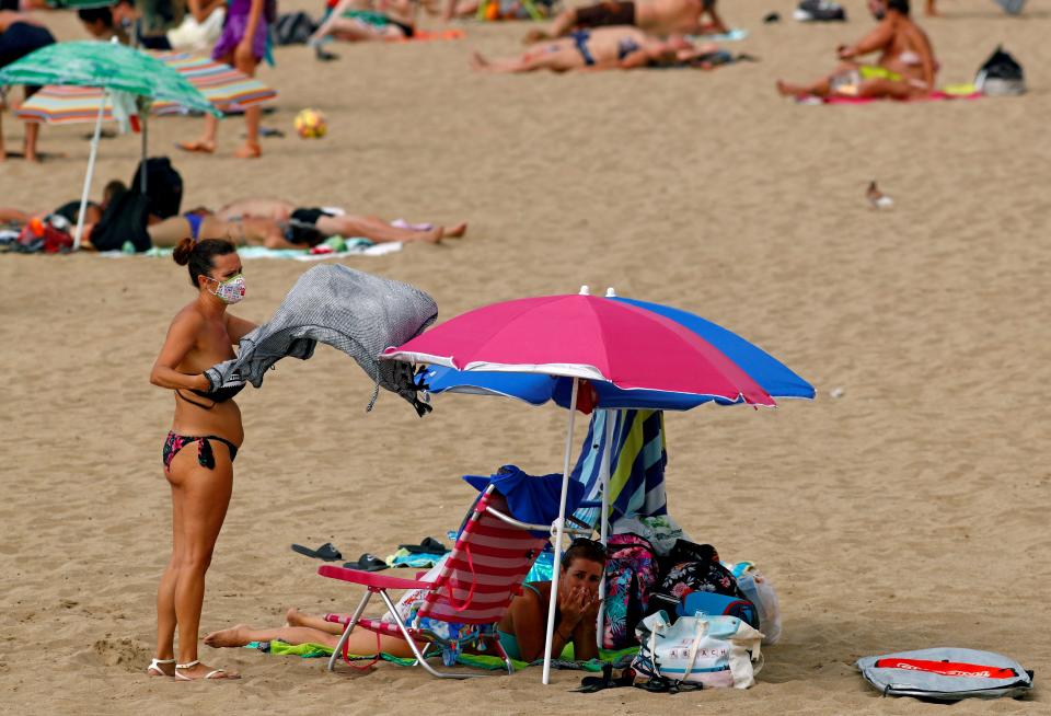 <p>A woman on the beach in Las Palmas in a mask</p> (REUTERS)