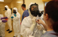 Health care workers prepare to transport a COVID-19 patient from an intensive care unit (ICU) at a hospital in Kyjov to hospital in Brno, Czech Republic, Thursday, Oct. 22, 2020. With cases surging in central Europe, some countries are calling in soldiers, firefighters, students and retired doctors to help shore up buckling health care systems. Many faced a shortage of medical personnel even before the pandemic, and now the virus has sickened many health workers, compounding the shortfall. (AP Photo/Petr David Josek)