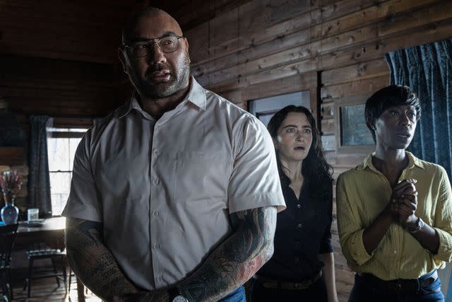 Phobymo/Universal Pictures From left: Dave Bautista, Abby Quinn and Nikki Amuka-Bird in 'Knock at the Cabin,' 2023