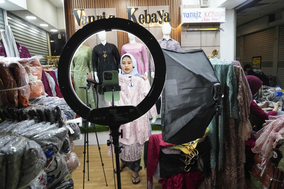 A trader conducts live sales via streaming at a store in the Tanah Abang textile market in Jakarta, Indonesia Thursday, Sept. 28, 2023. Chinese-owned app TikTok on Thursday said it regretted the Indonesian government's decision to ban e-commerce transactions on social media platforms, particularly the impact it would have on the millions of sellers who use TikTok Shop. (AP Photo/Tatan Syuflana)
