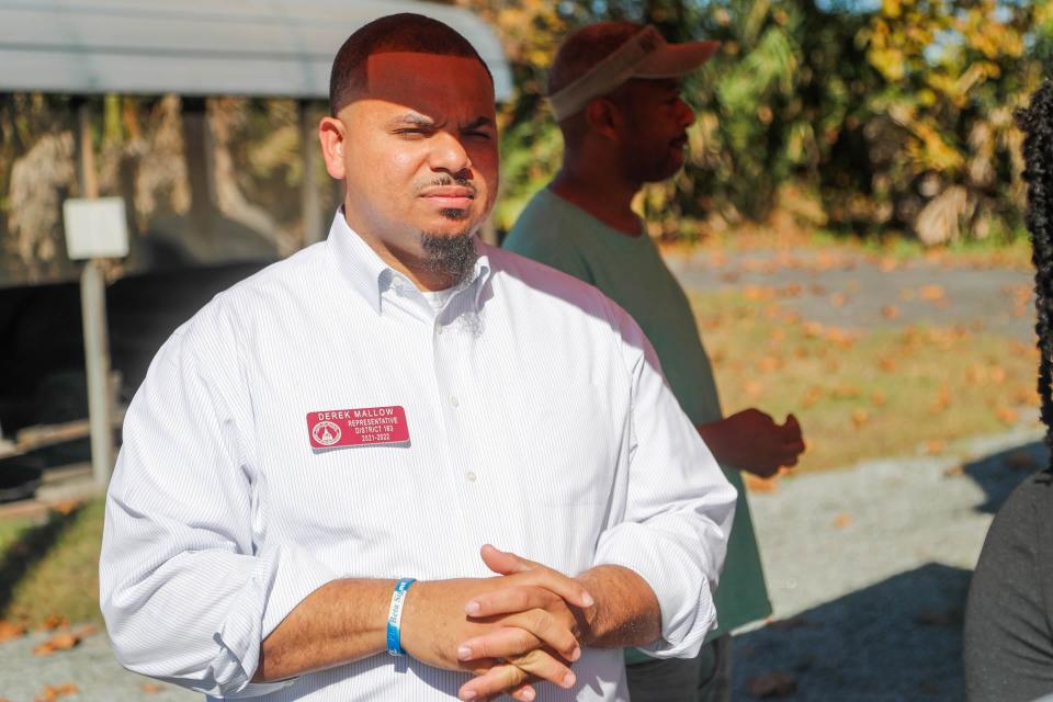 Derek Mallow, candidate of Georgia State Senate finds a little shade form the hot sun while waiting in line at Randy's Bar B Q on Tuesday November 8, 2022.