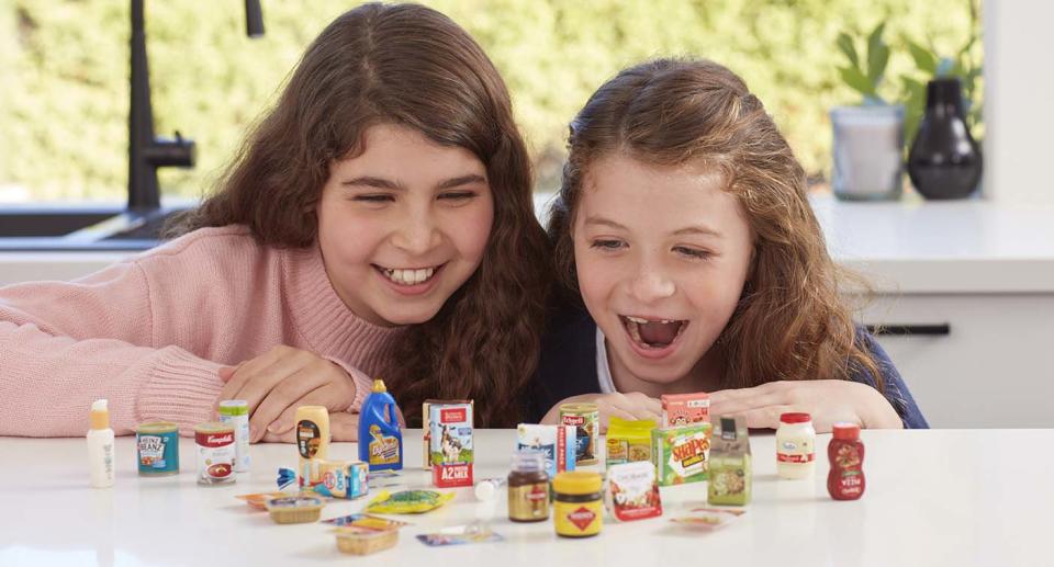 Two girls pictured looking over the new range of Coles Little Shop 2 collectables.