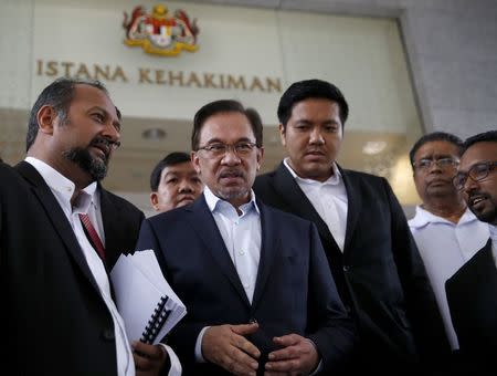 Malaysia's opposition leader Anwar Ibrahim is seen with his defence team as he leaves the court during his final appeal against a conviction for sodomy at the Palace of Justice in Putrajaya October 30, 2014. REUTERS/Olivia Harris