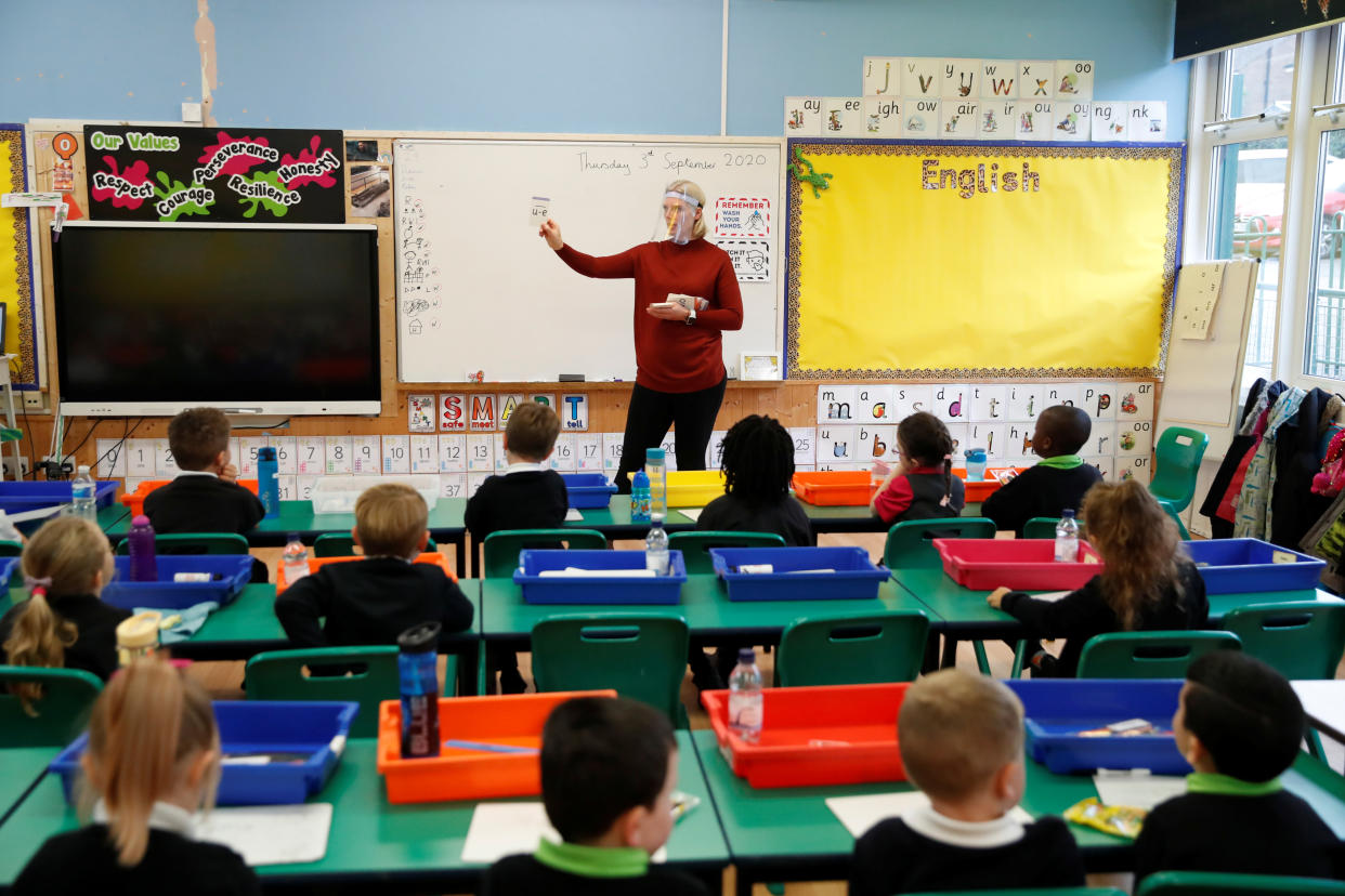 A teacher wearing a face shield works on the first day of school at Holne Chase Primary School, amid the outbreak of the coronavirus disease (COVID-19), in Milton Keynes, Britain, September 3, 2020. REUTERS/Andrew Boyers