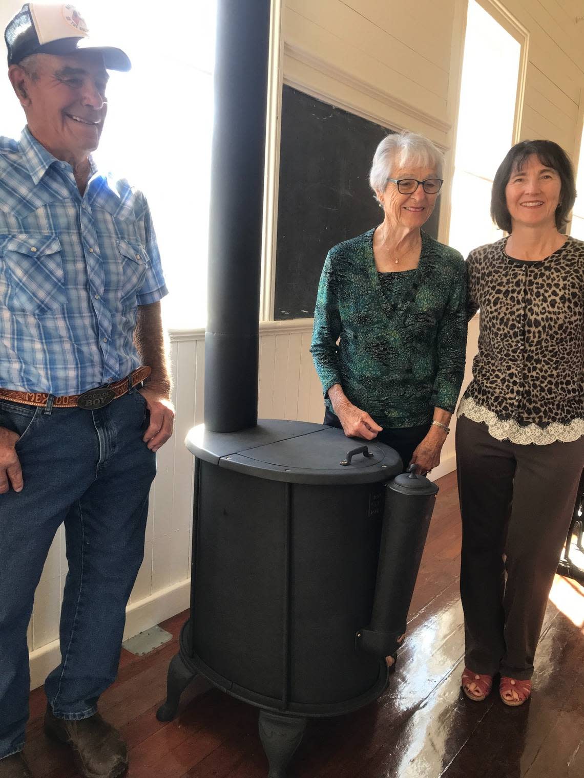 Oly Fiscalini, left, Kathleen Fiscalini Gerhardt and her daughter Debbie Soto gather around a historic stove that Paul and Brian Snow had restored and reinstalled for free. They and their parents, Curt Snow and Karen Soto Snow, also are members of pioneer Cambria families.