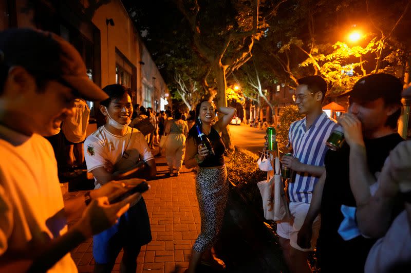 Personas beben en una calle, mientras la ciudad se prepara para poner fin al confinamiento establecido para frenar el brote de la enfermedad coronavirus (COVID-19) en Shanghái, China