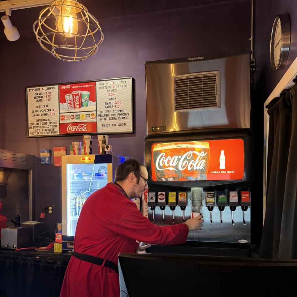 A.J. Parker, Capitol Arts Complex administrative assistant and resident Oscars expert, pours a soda at the concession stand.