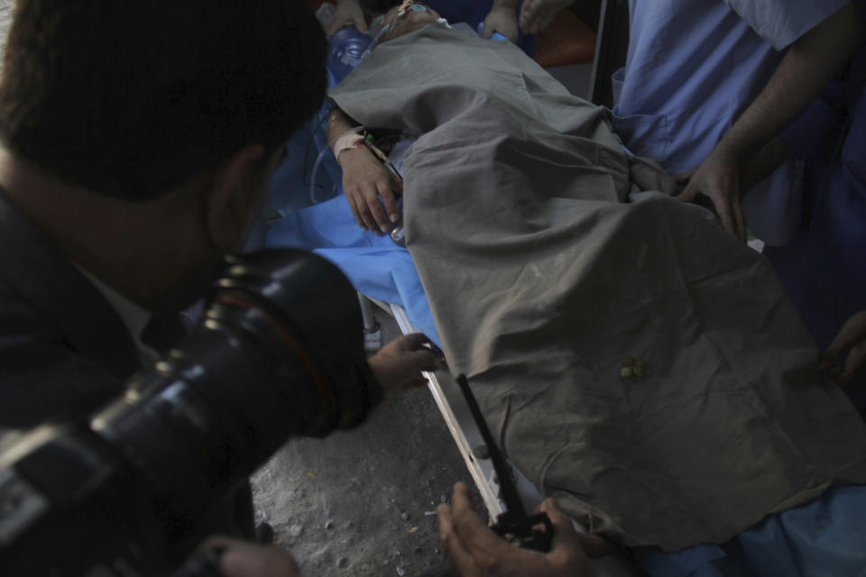 Locals carry an injured Japanese aid worker doctor Tetsu Nakamura at a hospital in Jalalabad eastern Afghanistan, Wednesday, Dec. 4, 2019. Nakamura died from his wounds after an attack that also killed five Afghans, including the doctor's bodyguards, the driver and a passenger. (AP Photo/Wali Sabawoon)