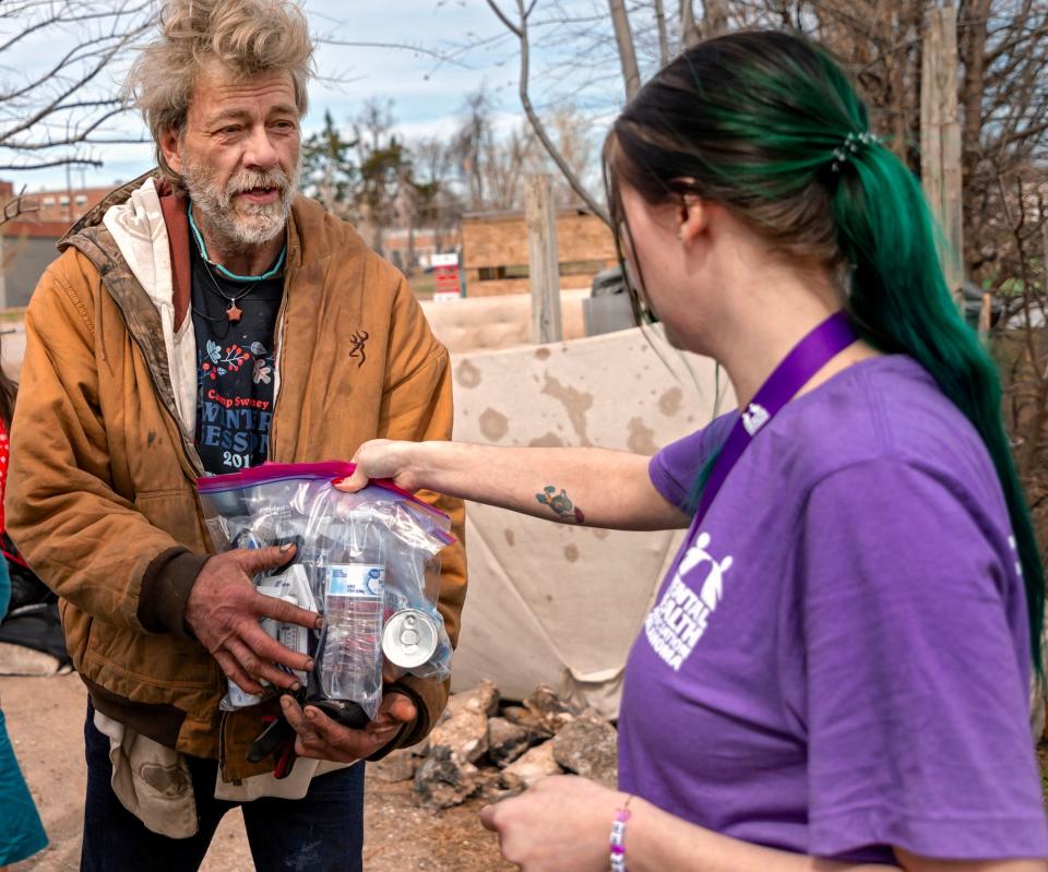 Homeless client Jeff D. receives supplies from Haley Graham on March 6 during a Mental Health Association of Oklahoma homeless outreach stop in Oklahoma City.