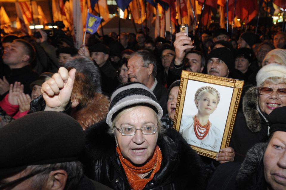 A protester holds up a photo of the imprisoned former Ukrainian Prime Minister, Yulia Tymoshenko, as supporters of the Ukrainian Opposition party take part in a rally outside the Central Elections Commission building in Kiev, Ukraine, Monday, Nov. 12, 2012. (AP Photo/Sergei Chuzavkov)