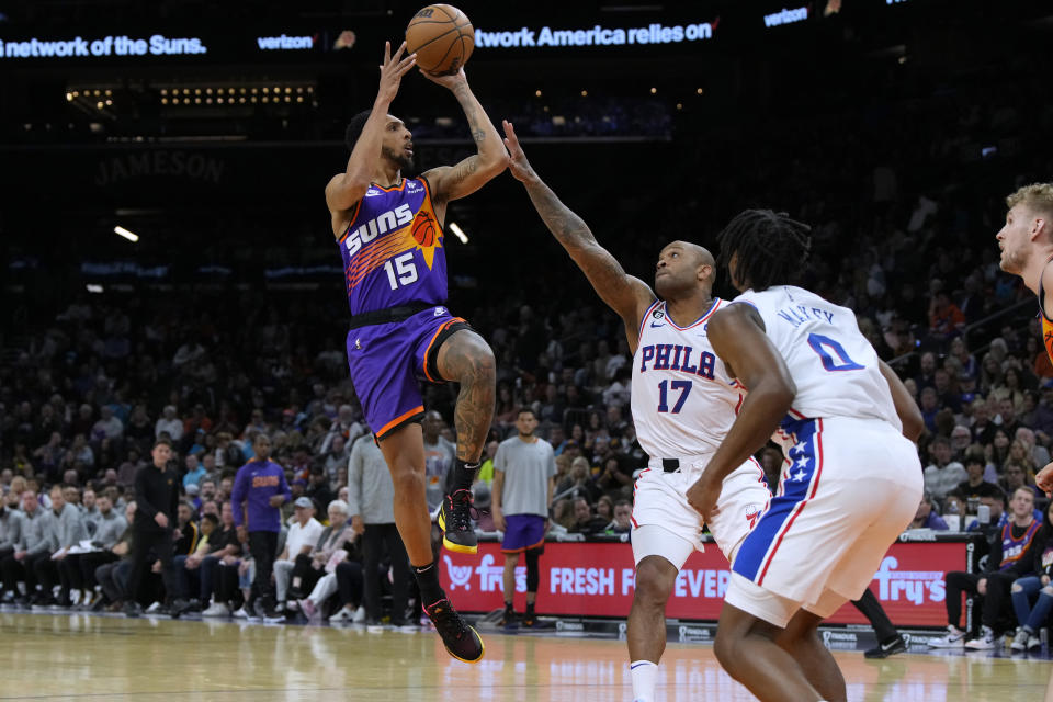 Phoenix Suns guard Cameron Payne (15) shoots over Philadelphia 76ers forward P.J. Tucker and guard Tyrese Maxey (0) during the second half of an NBA basketball game Saturday, March 25, 2023, in Phoenix. The Suns won 125-105. (AP Photo/Rick Scuteri)