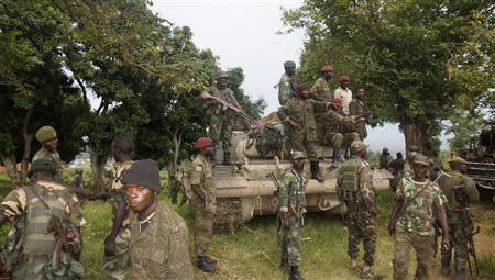 Congolese soldiers pose on a tank to celebrate their victory after taking over the headquarters of the M23 rebels at Rutshuru, north of Goma, October 28, 2013. REUTERS/Kenny Katombe