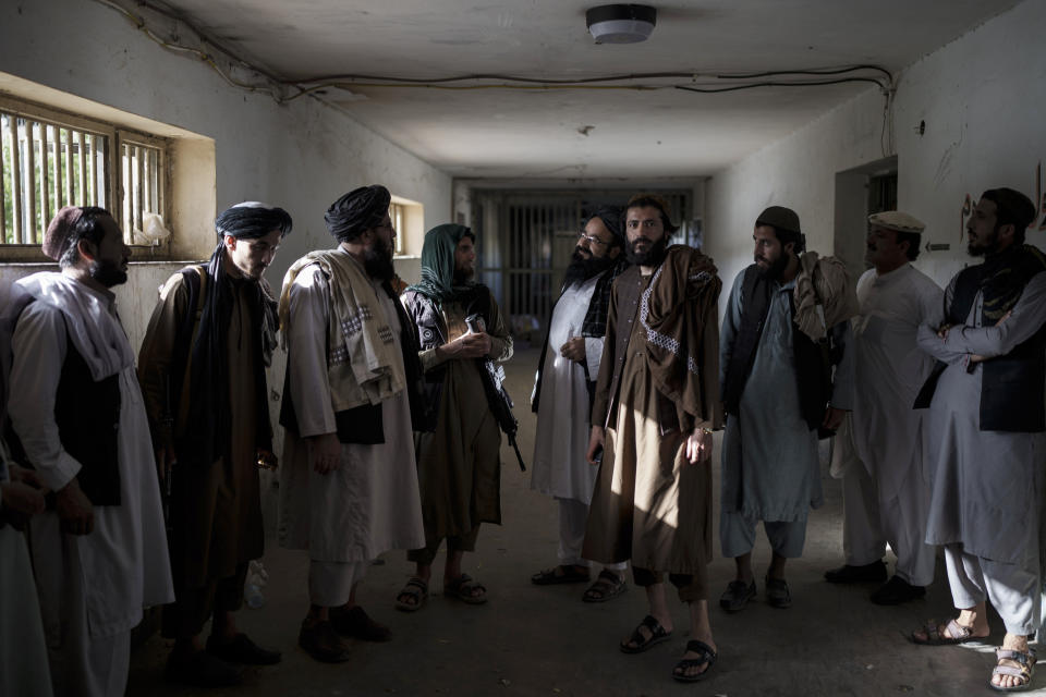 Taliban fighters, some former prisoners, chat in an empty area of the Pul-e-Charkhi prison in Kabul, Afghanistan, Monday, Sept. 13, 2021. Pul-e-Charkhi was previously the main government prison for holding captured Taliban and was long notorious for abuses, poor conditions and severe overcrowding with thousands of prisoners. Now after their takeover of the country, the Taliban control it and are getting it back up and running, current holding around 60 people, mainly drug addicts and accused criminals. (AP Photo/Felipe Dana)