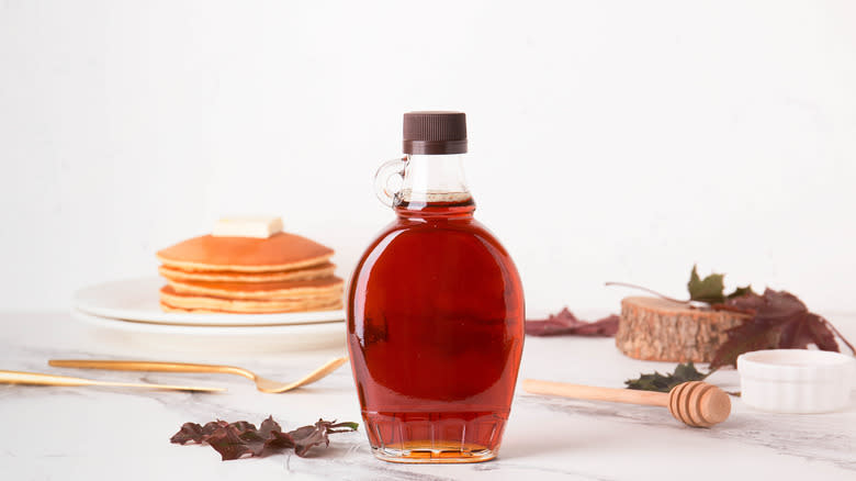 glass jar of maple syrup on counter with other items
