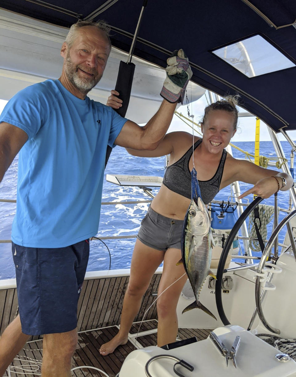 Kristen Pankratz and her father David pose on their yacht Amazing Grace in Tahiti on April, 1, 2020. Pankratz gave up her advertising job in Dallas and set sail with her parents in January. But now, along with hundreds of other sailors, the family finds themselves stranded in paradise.They made it as far as Tahiti in remote French Polynesia, one of the last places to offer refuge as borders slammed shut. (Kristen Pankaratz via AP)