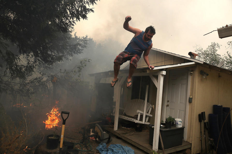 A resident jumps from his home's roof as a wildfire moves through Glen Ellen, California.