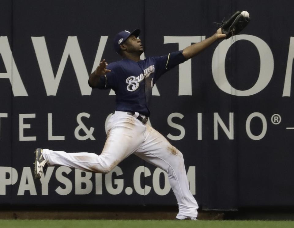 Milwaukee Brewers' Lorenzo Cain can't catch a ball hit by Los Angeles Dodgers' Chris Taylor during the ninth inning of Game 1 of the National League Championship Series baseball game Friday, Oct. 12, 2018, in Milwaukee. (AP Photo/Matt Slocum)