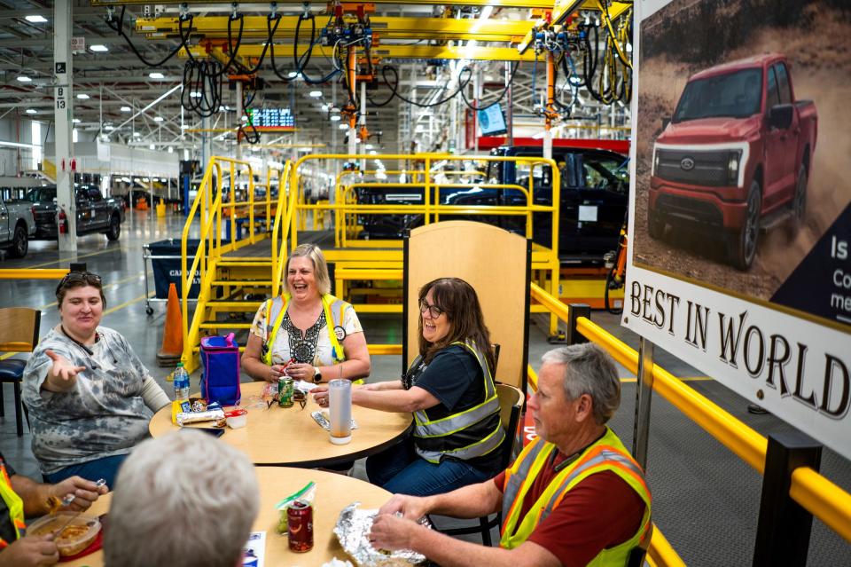 Suzie Roksandich-McDermott, right, and her daughter, Amanda McDermott, left, eat with other coworkers during their lunch break at the Rouge Electric Vehicle Center in Dearborn on Monday, May 15, 2023. Roksandich-McDermott and her daughter are the only mother/daughter team working on different sections of the assembly line in a plant that's preparing to double its run rate to 150,000 vehicles annually.