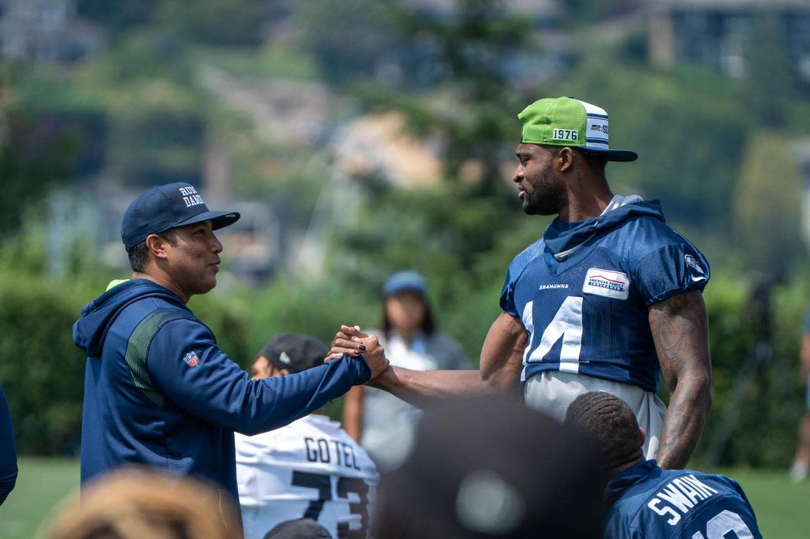 Seattle Seahawks wide receiver DK Metcalf greets running back coach Chad Morton during the first day of training camp at the Virginia Mason Athletic Center on July 27, 2022.