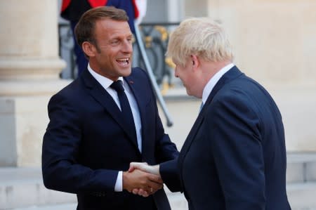 French President Emmanuel Macron accompanies British Prime Minister Boris Johnson after a meeting on Brexit at the Elysee Palace in Paris