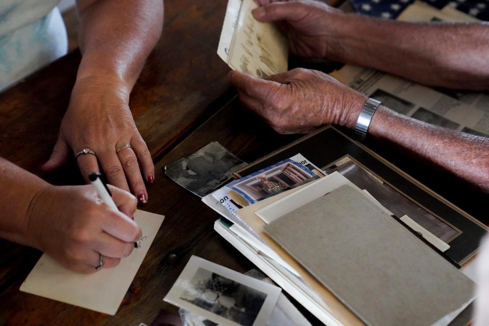 Lori Galanti, of Milan, and Duane Reum, 88, of Charlotte, sift through family memorabilia during the 115th annual Rendel Family Reunion in Milan on July 30, 2023.