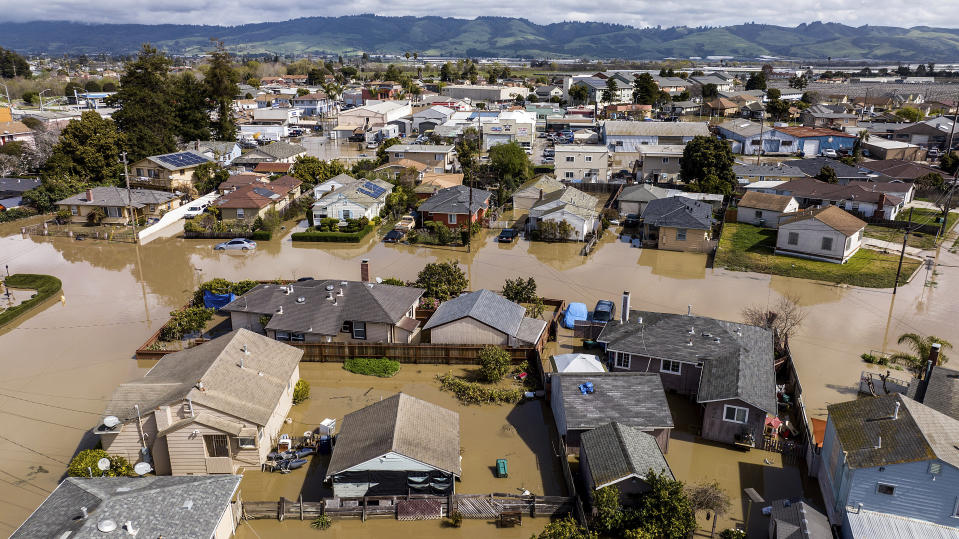 Floodwaters surround homes and vehicles in the community of Pajaro in Monterey County, Calif., on Monday, March 13, 2023. (AP Photo/Noah Berger)