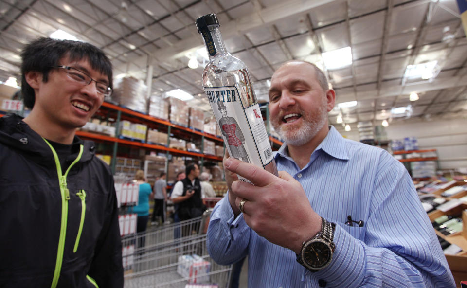Distiller Rusty Figgins, right, signs a bottle of his Batch 206 Distillery gin for customer Kevin Louie at a Costco warehouse store Friday, June 1, 2012, in Seattle. Figgins signed the bottle "All the best, Happy Repeal Day." Private retailers begin selling spirits for the first time under a voter-approved initiative kicking the state out of the liquor business. The initiative allows stores larger than 10,000 square feet and some smaller stores to sell hard alcohol.(AP Photo/Elaine Thompson)